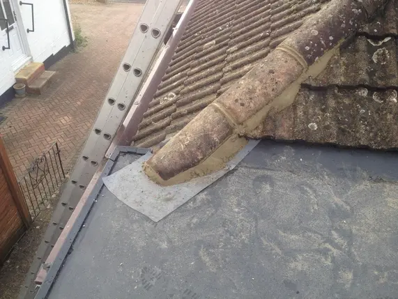 EPDM flat roof finished against a tiled roof slope
