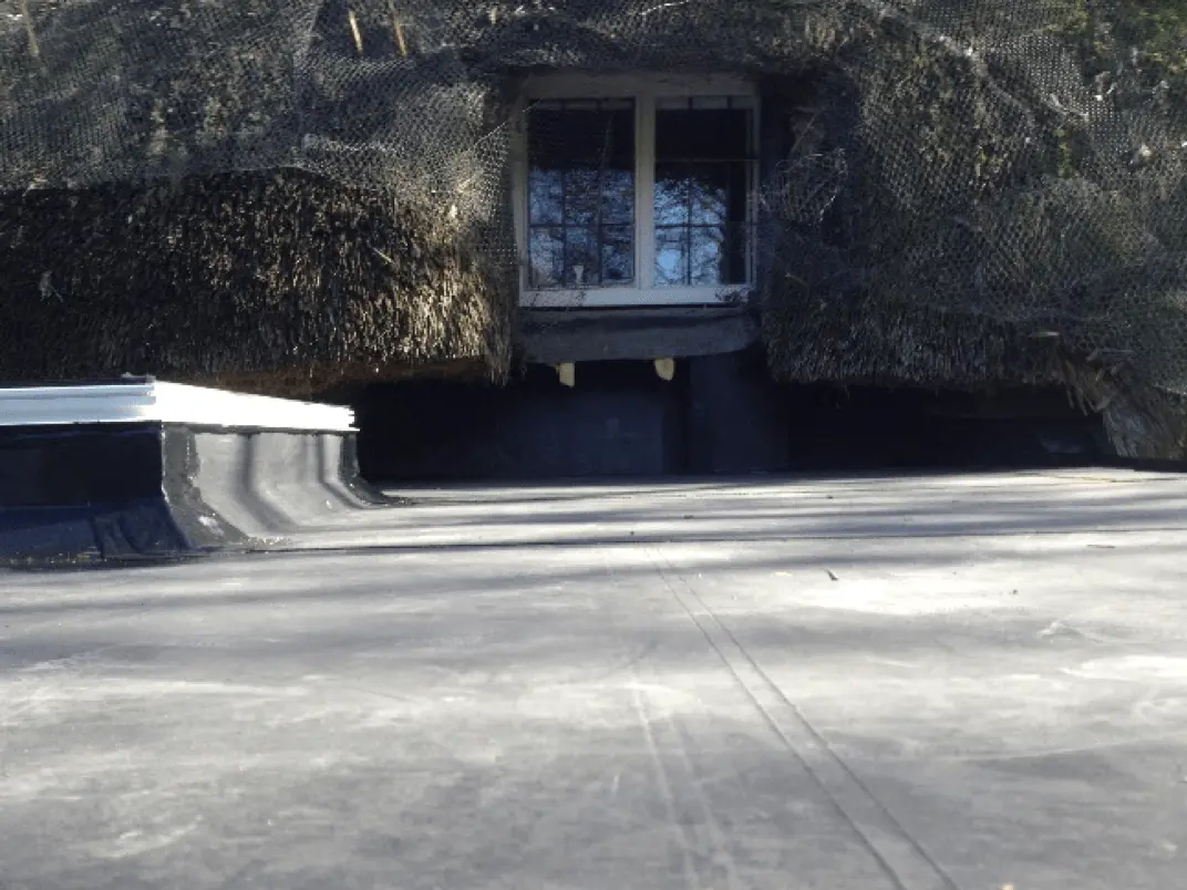Finished black EPDM rubber flat roof below a house window
