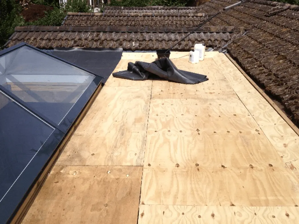 New plywood deck being laid for a flat roof with a rooflight opening