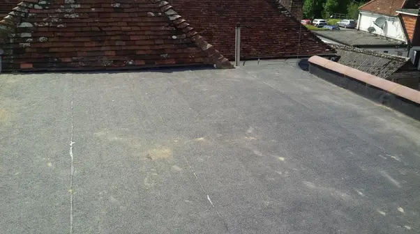 Dark grey flat roof beside a tiled roof
